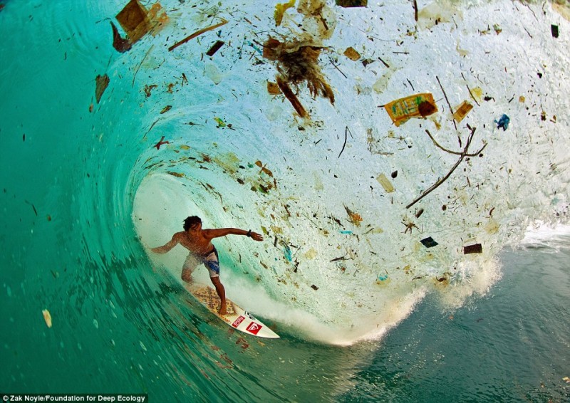 The Indonesian surfer Dede Surinaya rides a wave of filth and trash (Java, Indonesia).