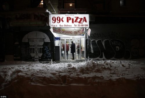 A магазин пица все още е отворена за бизнес в Долна източната част на Манхатън по време на голяма зимна буря в Ню Йорк късно в събота вечер